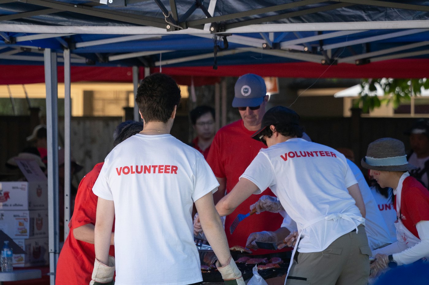 Volunteers organising donated items under a distribution tent